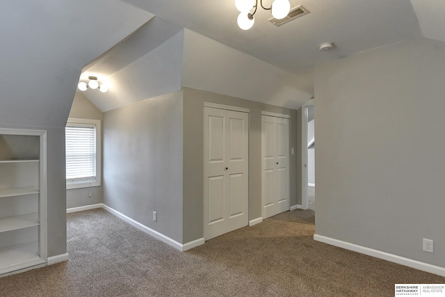 additional living space featuring visible vents, carpet, and lofted ceiling