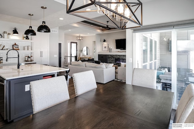 dining area featuring visible vents, an inviting chandelier, a fireplace, recessed lighting, and dark wood-style flooring