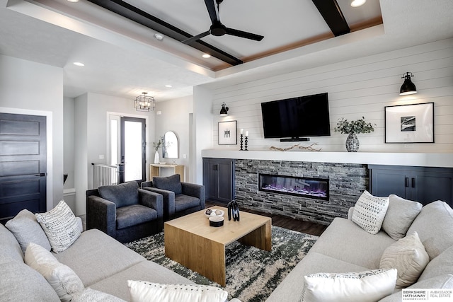 living area featuring wood finished floors, beam ceiling, a fireplace, recessed lighting, and ceiling fan