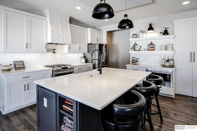 kitchen featuring open shelves, appliances with stainless steel finishes, dark wood-style flooring, and light countertops