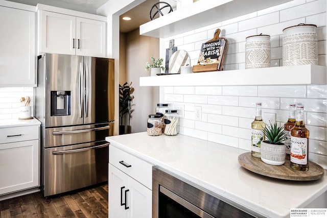 kitchen featuring tasteful backsplash, dark wood-style floors, white cabinetry, appliances with stainless steel finishes, and light countertops