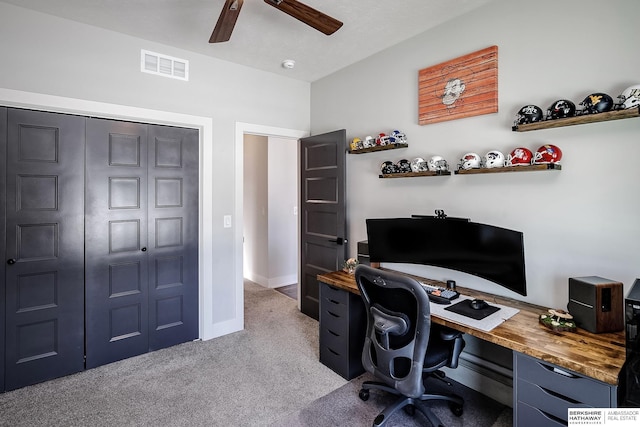 carpeted office featuring baseboards, visible vents, and ceiling fan