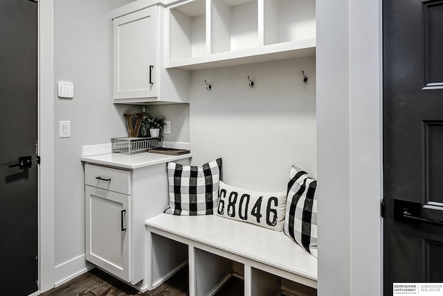 mudroom featuring baseboards and dark wood-style floors