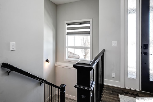 foyer featuring visible vents, baseboards, and dark wood-style flooring