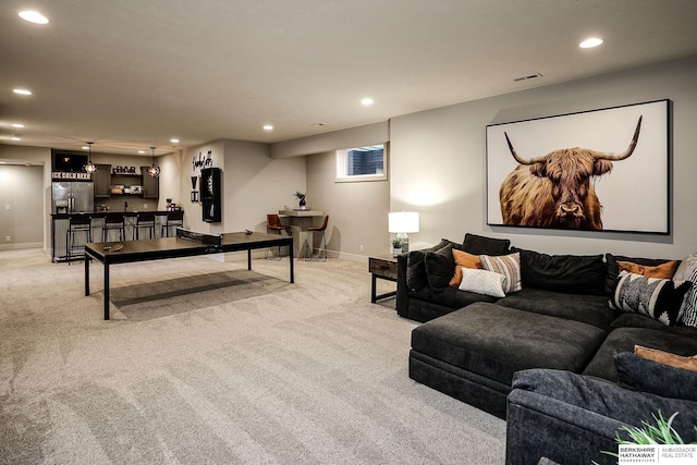 living room featuring indoor wet bar, recessed lighting, and light colored carpet