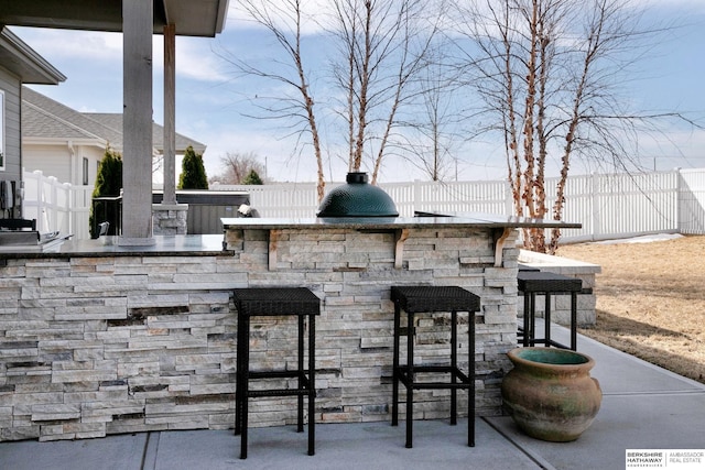 view of patio featuring a fenced backyard and exterior bar