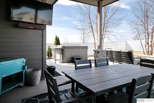 view of patio / terrace featuring a fenced backyard, outdoor dining space, and a hot tub