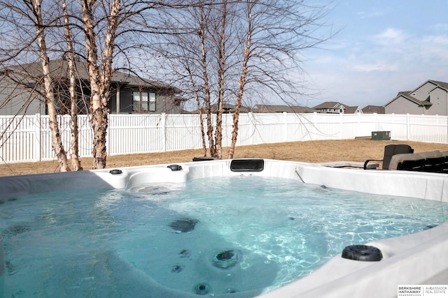 view of pool with a fenced backyard and a hot tub