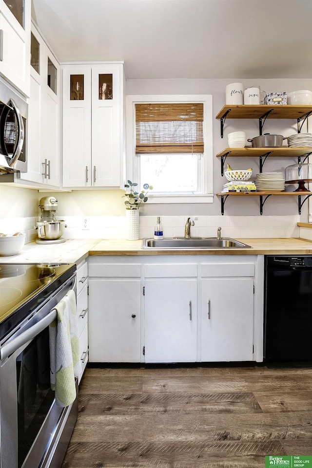 kitchen with dark wood-type flooring, light countertops, appliances with stainless steel finishes, white cabinetry, and a sink