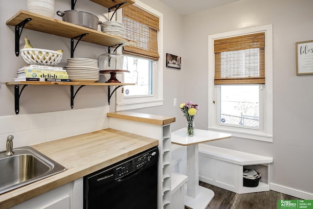 kitchen with dark wood finished floors, open shelves, a sink, wood counters, and dishwasher