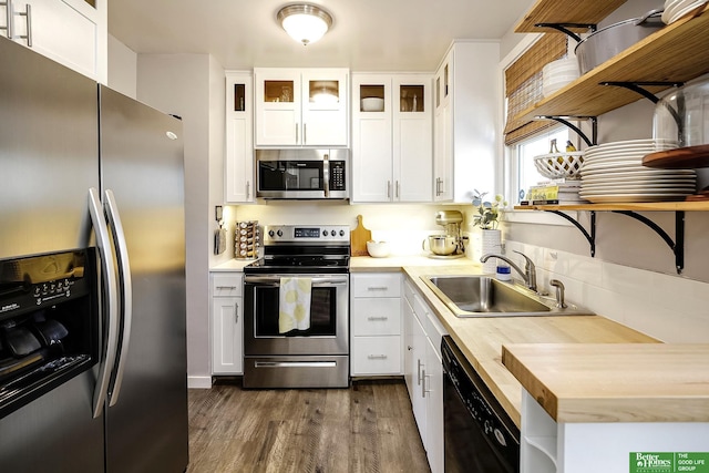 kitchen featuring dark wood-style floors, a sink, appliances with stainless steel finishes, and open shelves