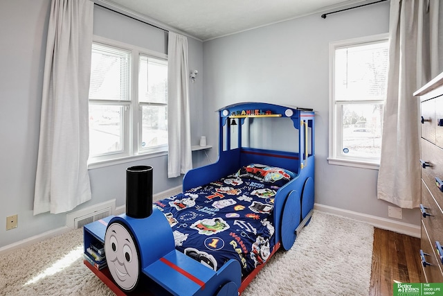 bedroom featuring multiple windows, visible vents, and baseboards