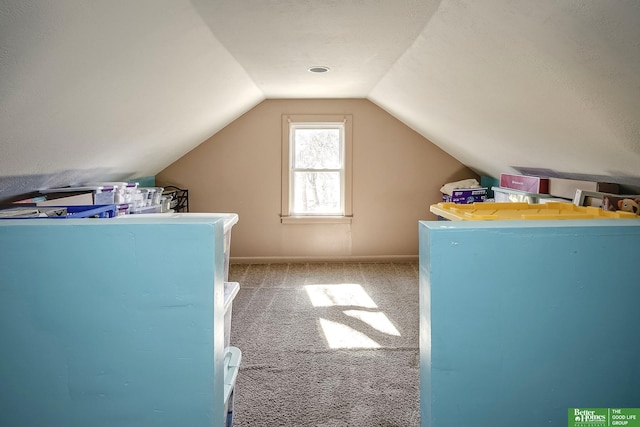 interior space featuring baseboards, carpet, and vaulted ceiling