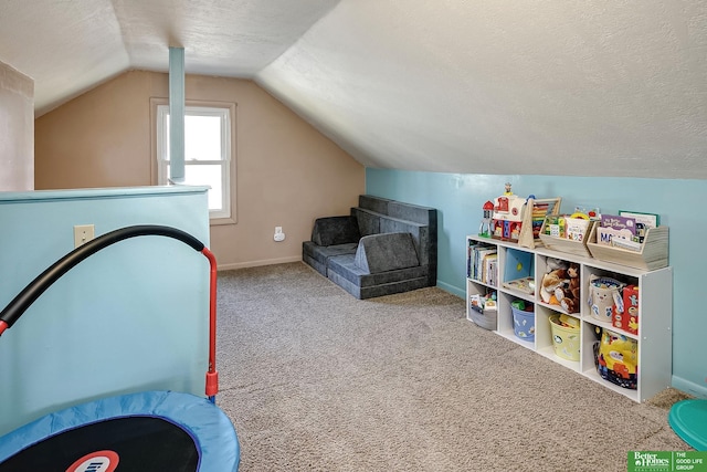 recreation room featuring carpet flooring, a textured ceiling, baseboards, and vaulted ceiling