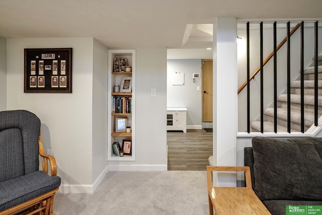 sitting room with stairway, carpet, and baseboards