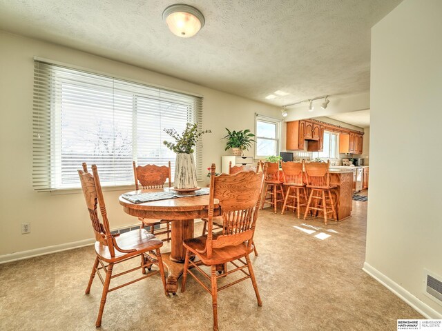 dining area with visible vents, baseboards, and a textured ceiling