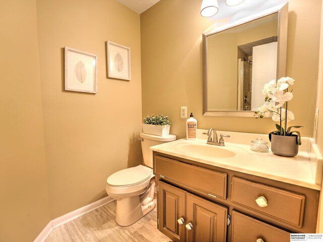 bathroom with toilet, vanity, and baseboards