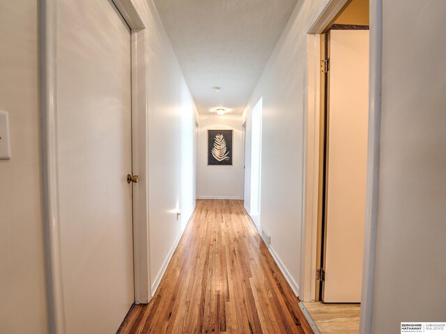 hall with baseboards and light wood-type flooring