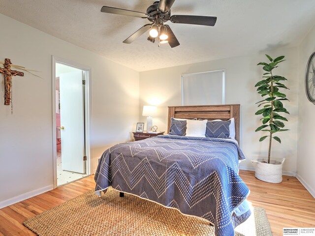 bedroom with a ceiling fan, baseboards, and light wood-type flooring