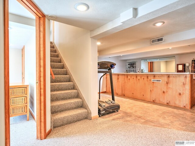 interior space with visible vents, baseboards, carpet, and a textured ceiling