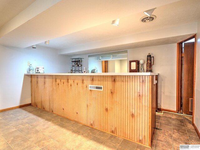 bar with visible vents, a bar, and baseboards