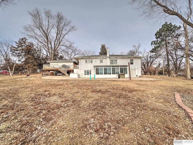 back of property with a wooden deck and a sunroom