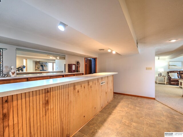 kitchen featuring light carpet, light countertops, and baseboards