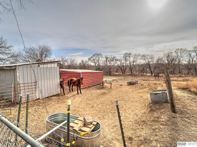 view of yard with an outdoor structure and a rural view