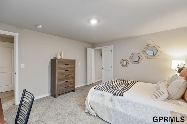 bedroom with light colored carpet and baseboards