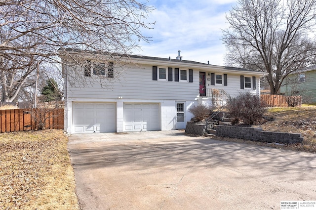 view of front of home featuring a garage, stairway, concrete driveway, and fence