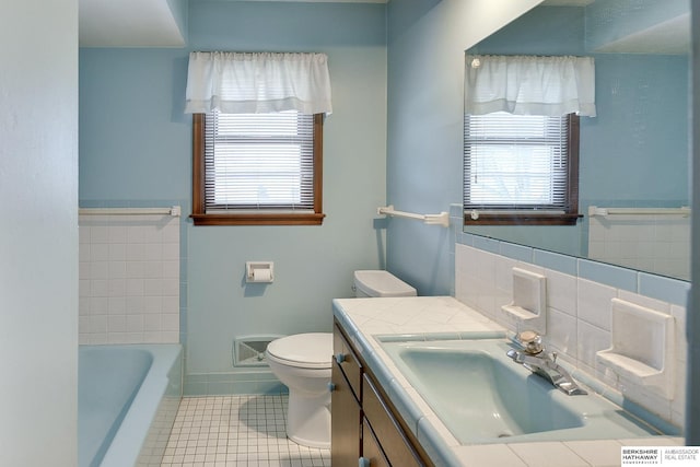 full bathroom with tile patterned floors, toilet, a healthy amount of sunlight, and vanity