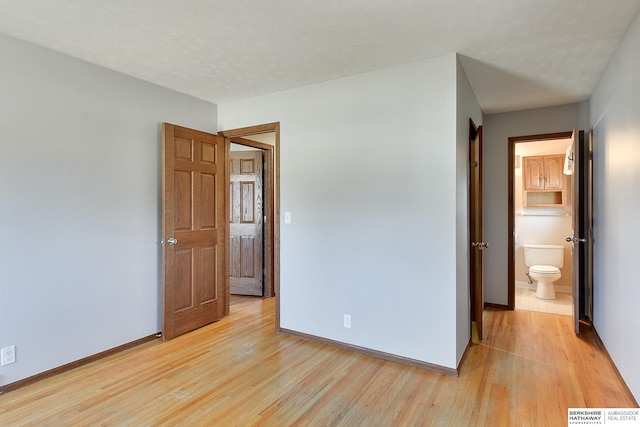 unfurnished bedroom featuring visible vents, baseboards, a textured ceiling, and light wood-style flooring