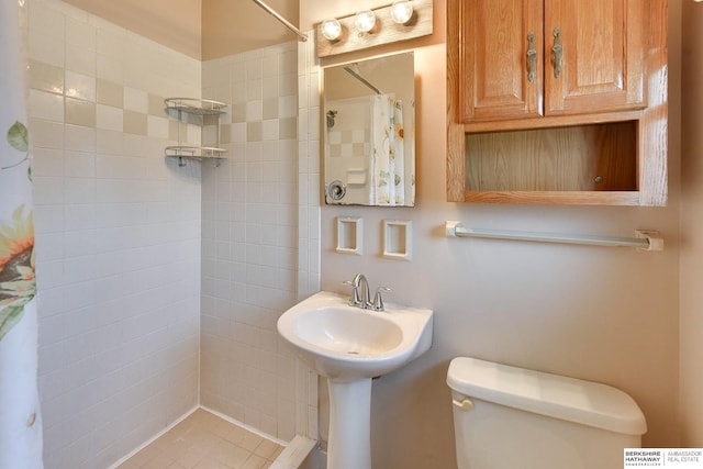 bathroom featuring toilet and tiled shower