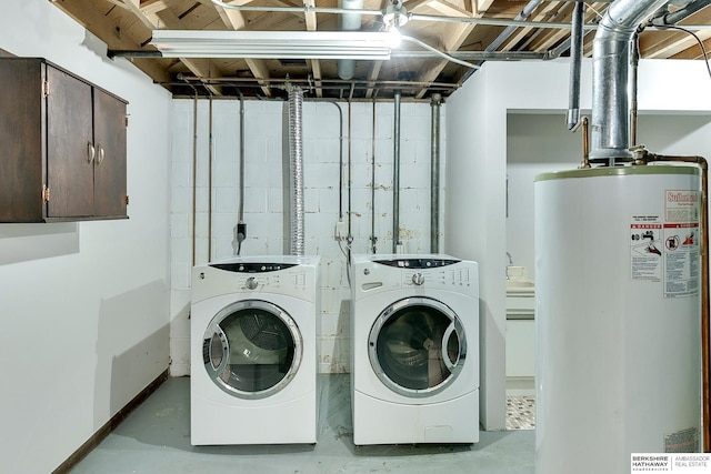 clothes washing area with baseboards, independent washer and dryer, water heater, and laundry area