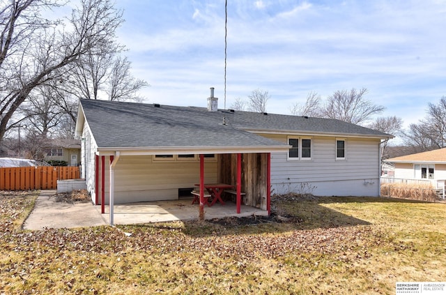 back of house with fence, roof with shingles, a chimney, a yard, and a patio