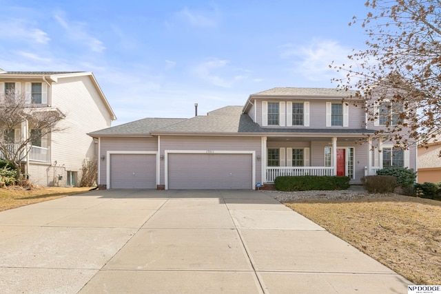 traditional-style home featuring a porch, a garage, driveway, and a shingled roof