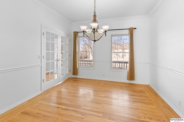 unfurnished dining area featuring a chandelier, baseboards, light wood-style floors, and ornamental molding