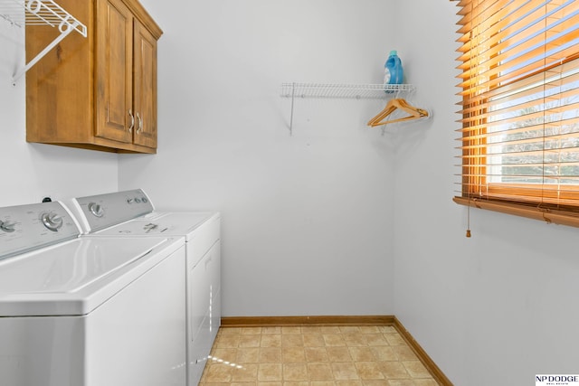 clothes washing area featuring cabinet space, baseboards, and separate washer and dryer