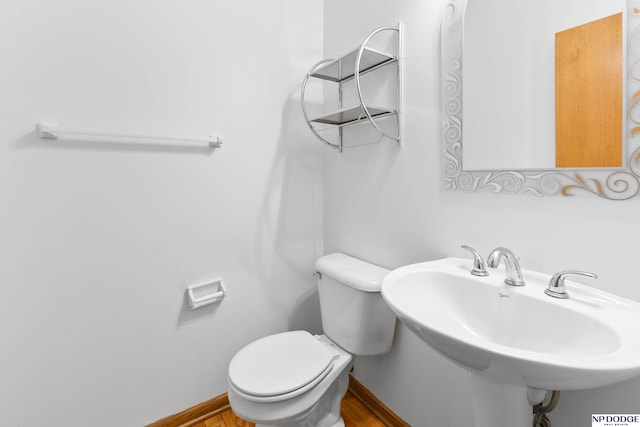 bathroom with a sink, baseboards, and toilet