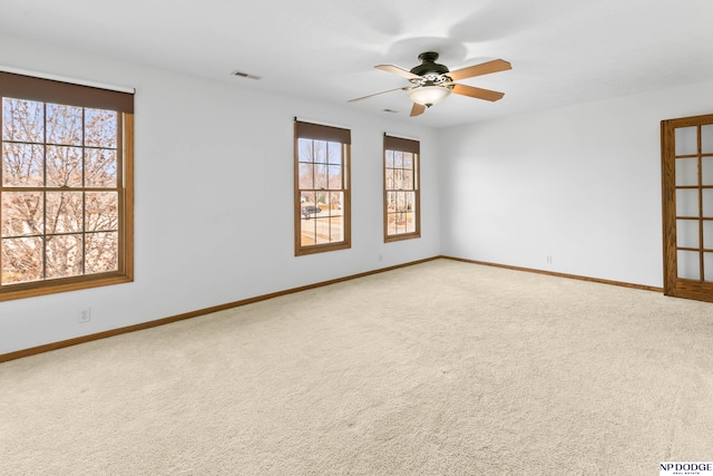 unfurnished room featuring baseboards, carpet floors, visible vents, and a ceiling fan