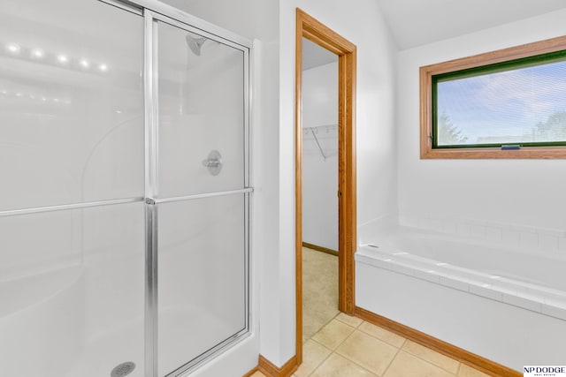 full bath with tile patterned flooring, a shower stall, a spacious closet, and a garden tub