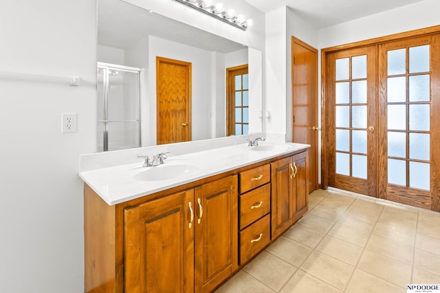 full bathroom with a sink, french doors, double vanity, and tile patterned floors