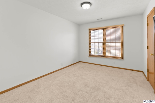 carpeted empty room featuring baseboards