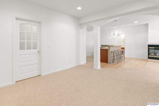 unfurnished living room with recessed lighting, a multi sided fireplace, arched walkways, carpet flooring, and baseboards