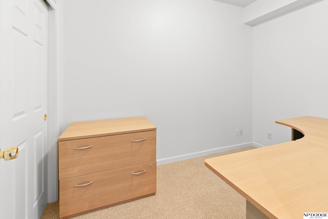 office featuring baseboards and light carpet