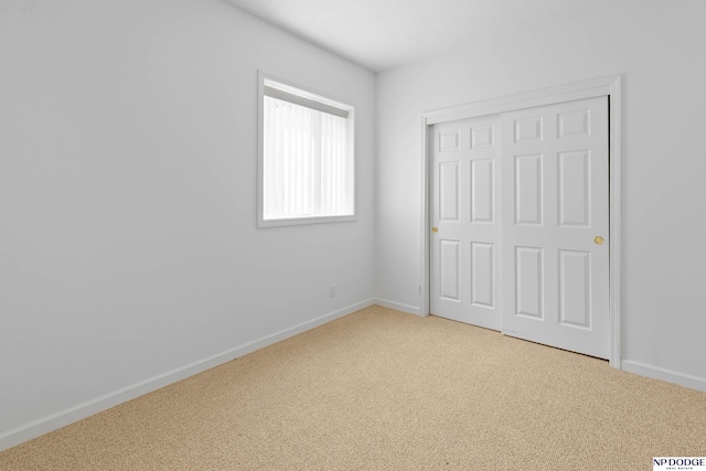 unfurnished bedroom featuring a closet, baseboards, and carpet