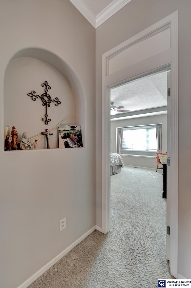 corridor with baseboards, carpet flooring, and crown molding