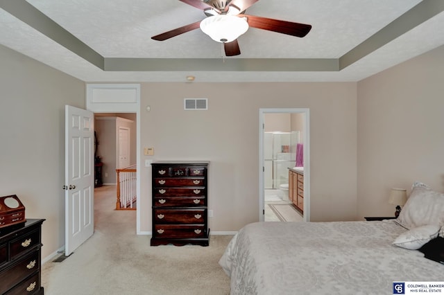 bedroom featuring visible vents, baseboards, light colored carpet, a textured ceiling, and a raised ceiling