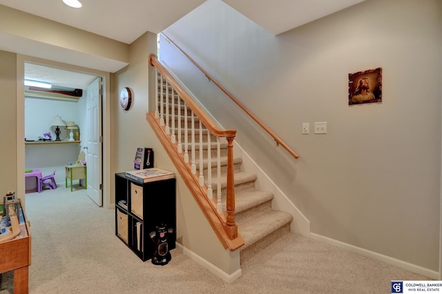 staircase featuring baseboards and carpet flooring