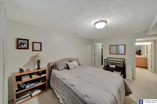 bedroom with light colored carpet, visible vents, and a textured ceiling